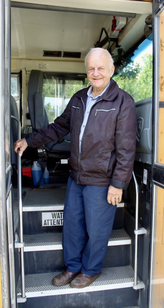 chauffeur d'autobus âgé de 87 ans souriant dans l'escalier de l'autobus, Monsieur Gilles Patry de Compton