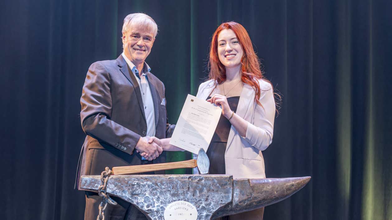 Une jeune femme recevant son jonc d'ingénieure lors d'une cérémonie officielle.