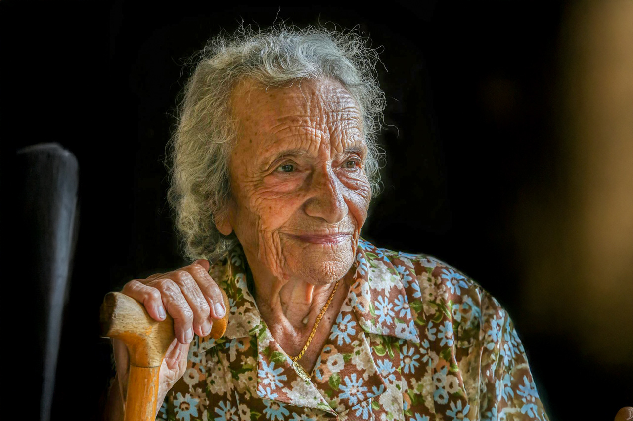 Une personne centenaire prend la pose avec une canne